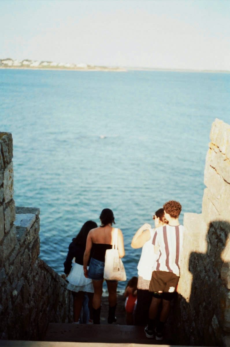 Two figures descending stone steps toward the water