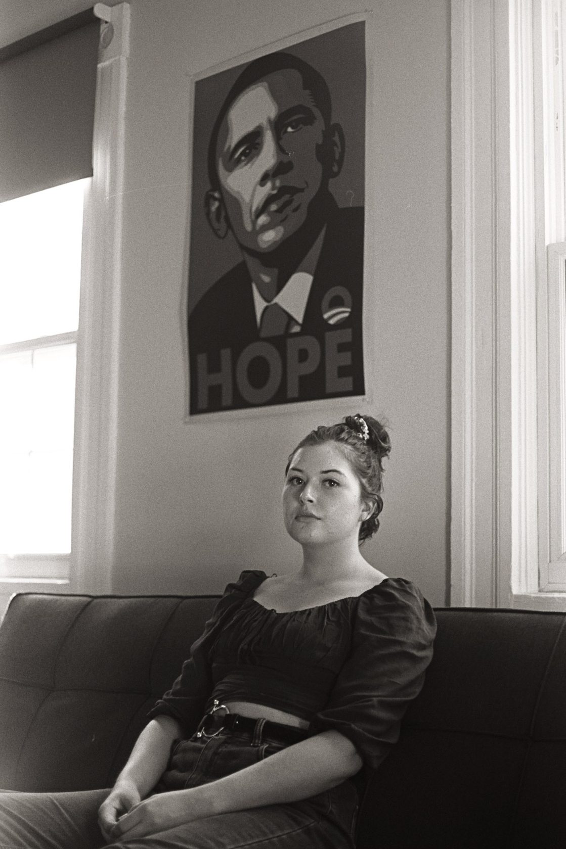 Black and white interior portrait beneath a poster reading HOPE