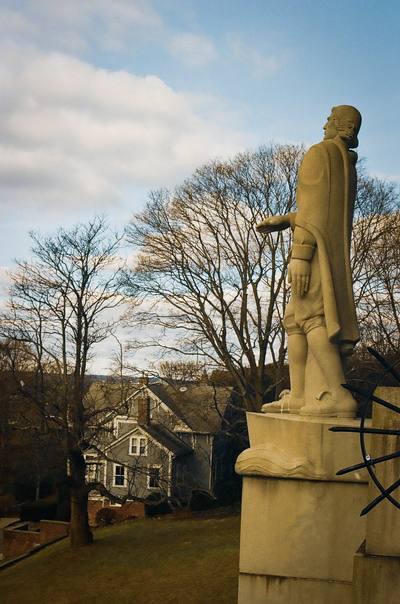 A statue on a pedestal among trees