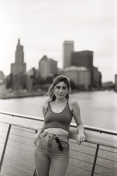 Portrait on a rooftop with a city skyline in the background, warm film tone
