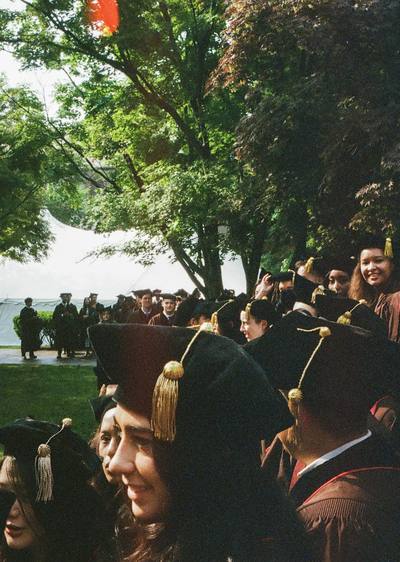 A wide view of graduates seated in caps and gowns at a commencement ceremony