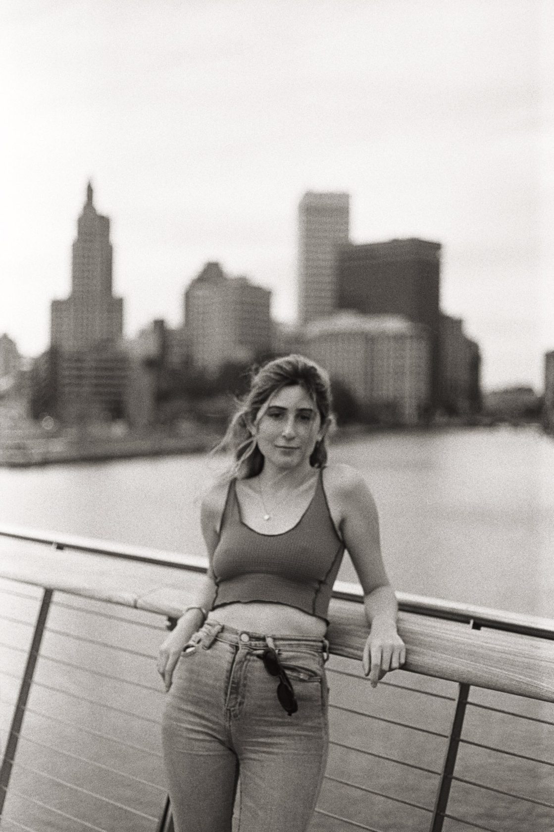 Portrait on a rooftop with a city skyline in the background, warm film tone