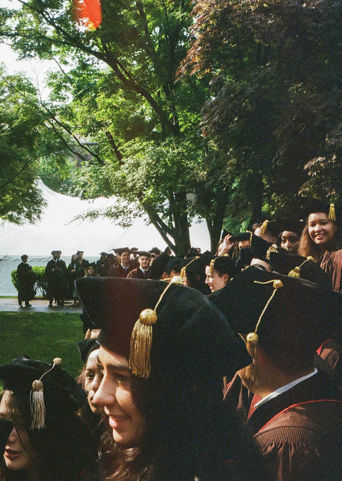 A wide view of graduates seated in caps and gowns at a commencement ceremony