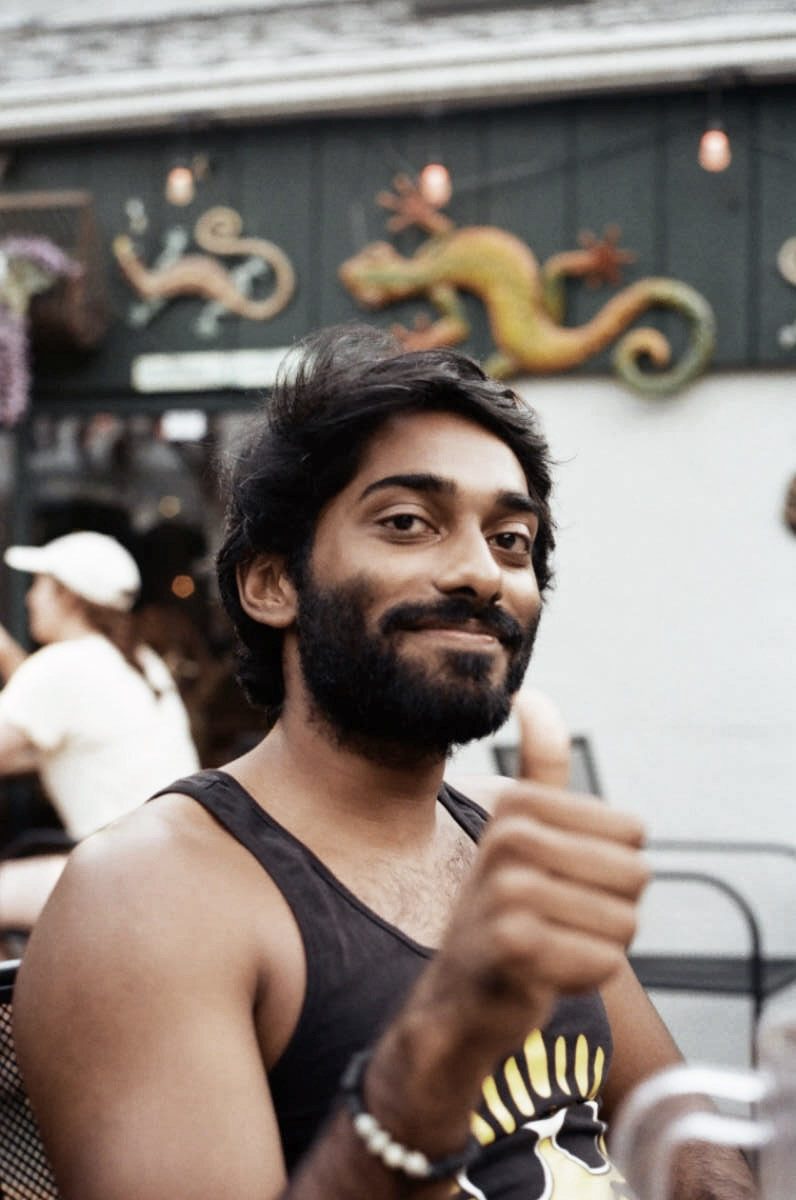 Portrait of a man giving a thumbs up in front of a street mural
